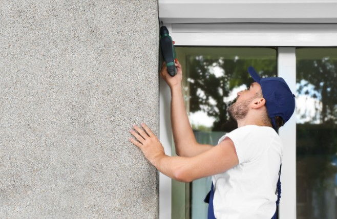 Persianista fijando el cajón de una persiana al dintel de una ventana durante una instalación en Burgos