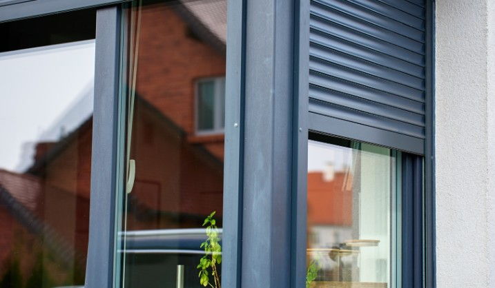Persiana de aluminio lacada en gris antracita recogida sobre la ventana oscura de un unifamiliar en Burgos