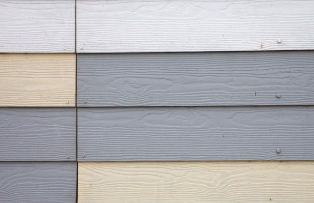 Revestimiento exterior de lamas horizontales gris y crema en la fachada de una vivienda unifamiliar